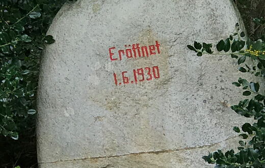 Ein großer Feldstein auf dem das Eröffnungsdatum des Quellenbad 01.06.1930 zu lesen ist
